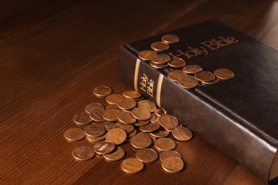 Photo of Donate and give concept. Coins and Bible on wooden table