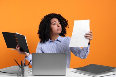 Stressful deadline. Emotional woman checking document at white table against orange background