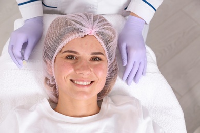 Woman undergoing face biorevitalization procedure in salon. Cosmetic treatment