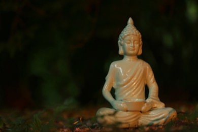 Photo of Decorative Buddha statue on ground outdoors, space for text