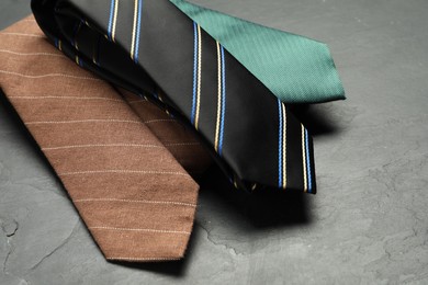 Photo of Different neckties on grey textured background, closeup