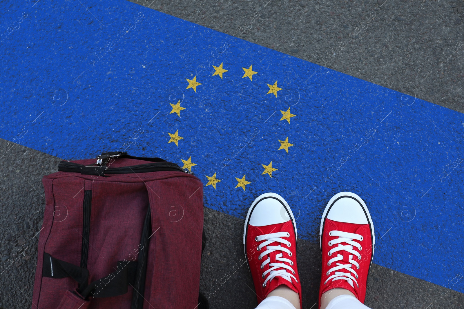 Image of Immigration. Woman with bag standing on asphalt near flag of European Union, top view