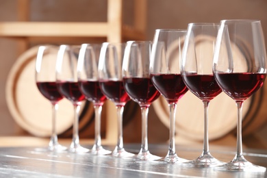 Photo of Glasses with delicious red wine on table