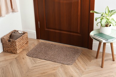 Clean door mat on wooden floor in hall