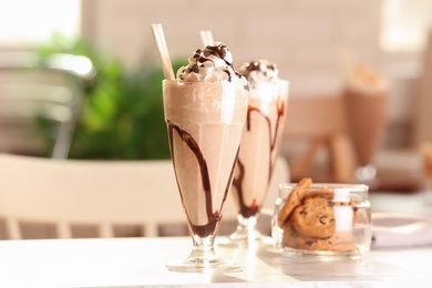 Photo of Glass with delicious milk shake on table indoors