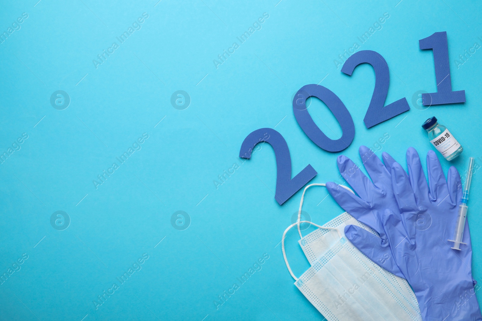 Photo of Flat lay composition with coronavirus vaccine and number 2021 on light blue background, space for text