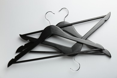 Photo of Black hangers on light gray background, top view
