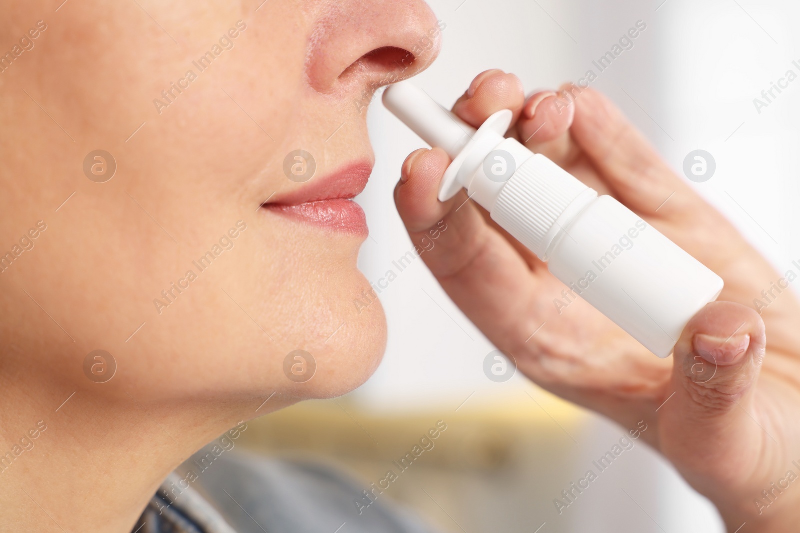 Photo of Medical drops. Woman using nasal spray indoors, closeup