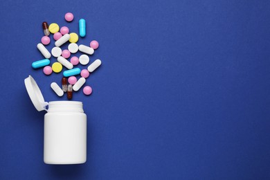 Photo of Bottle and antidepressant pills on dark blue background, flat lay. Space for text