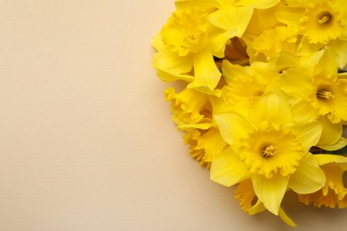 Photo of Beautiful daffodil bouquet on beige background, closeup. Space for text