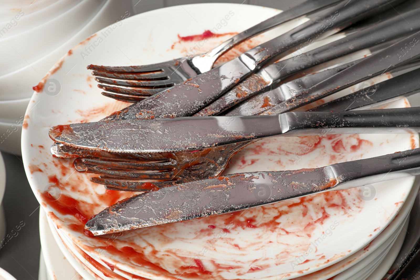 Photo of Stack of dirty dishes with cutlery, closeup