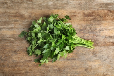 Photo of Bunch of fresh green parsley on wooden background, view from above