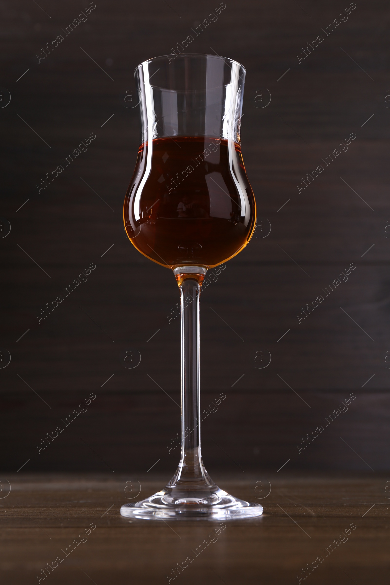 Photo of Delicious liqueur in glass on wooden table