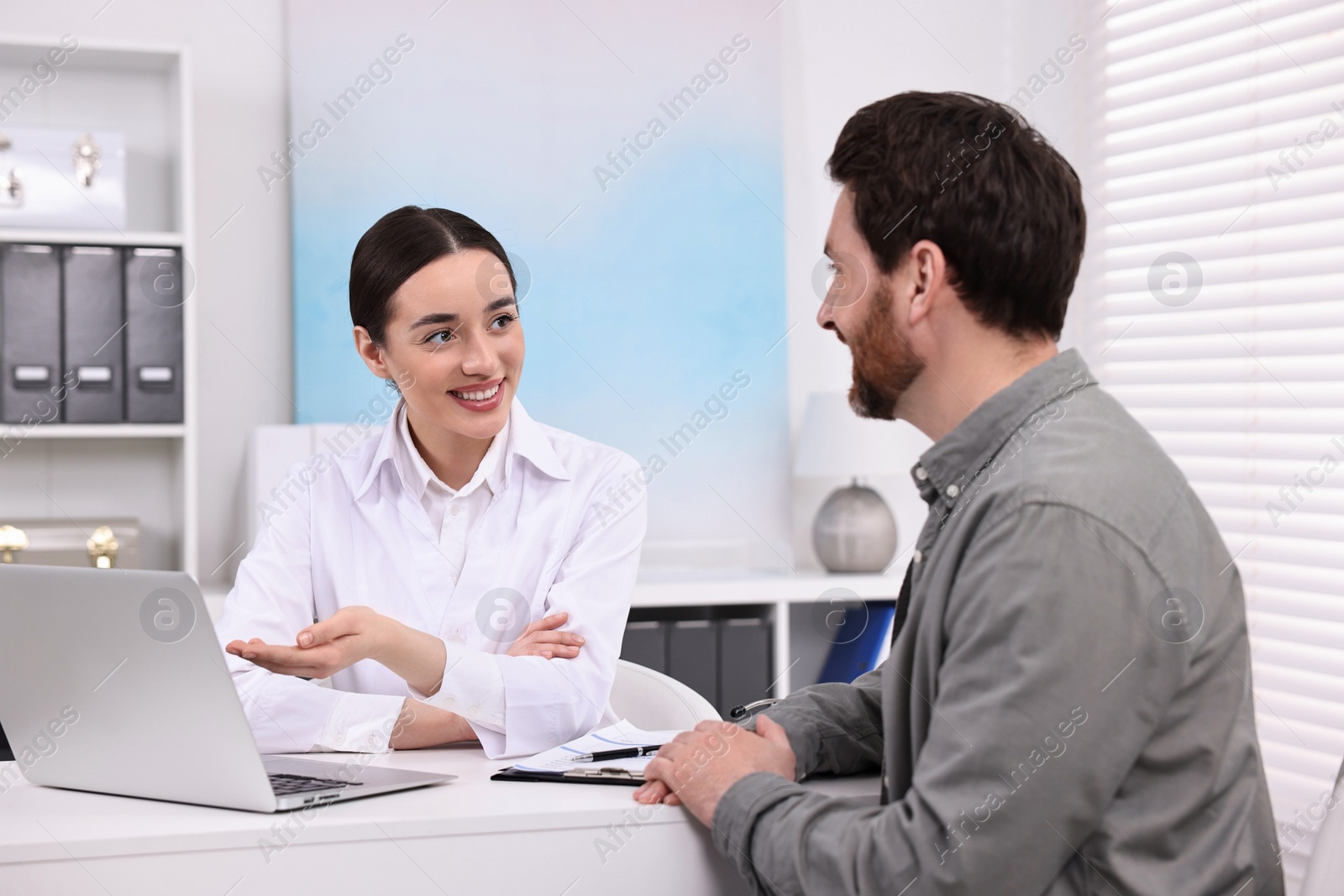 Photo of Doctor consulting patient during appointment in clinic