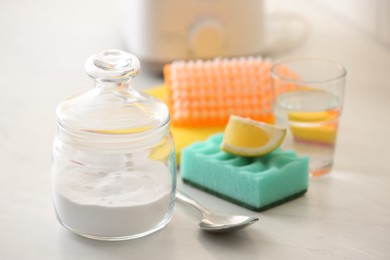 Photo of Baking soda, lemon and vinegar on light stone table. Eco friendly detergents