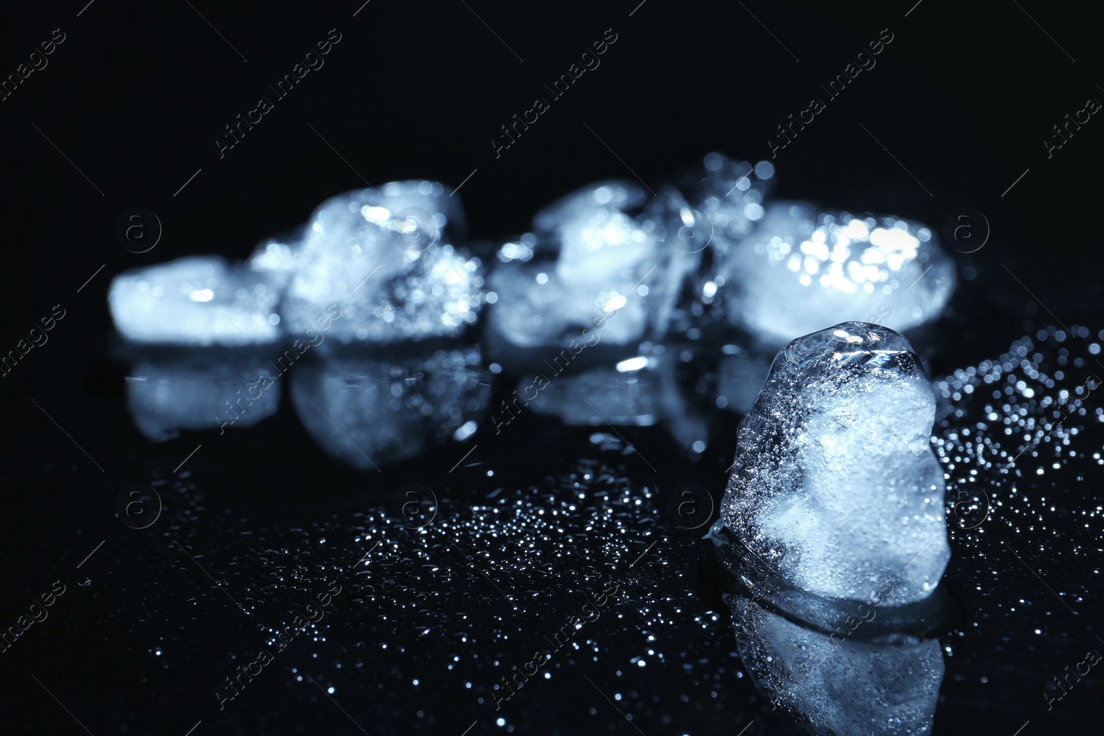 Photo of Melting ice cube on blurred background. Space for text