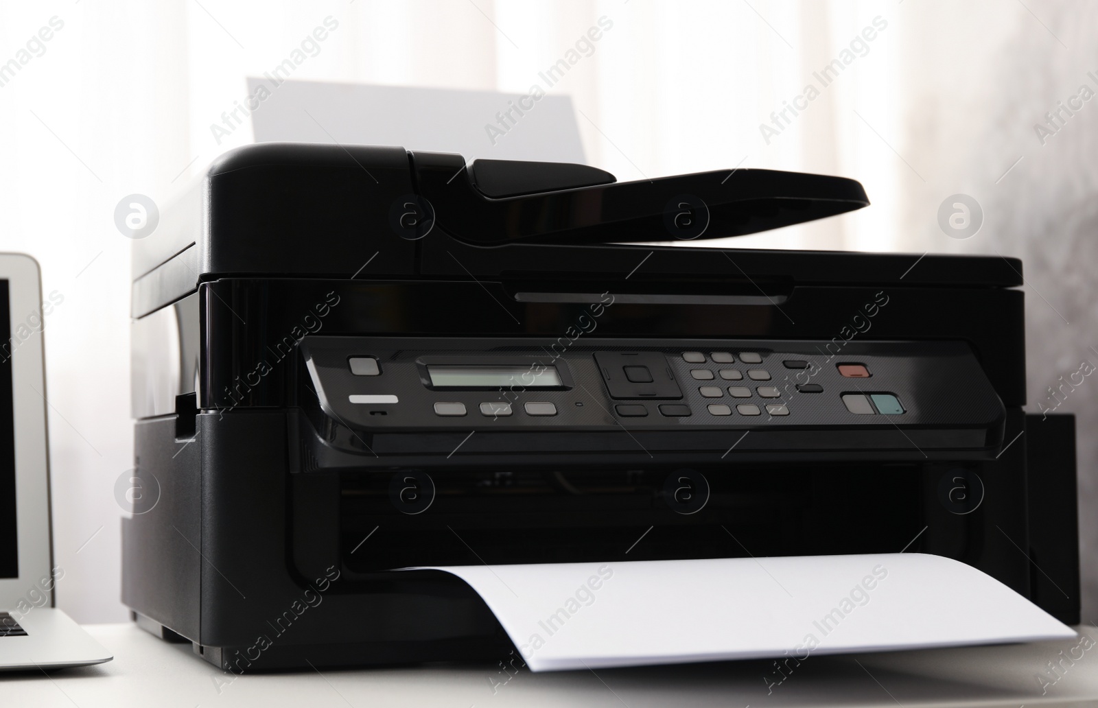 Photo of Modern printer with paper on white table