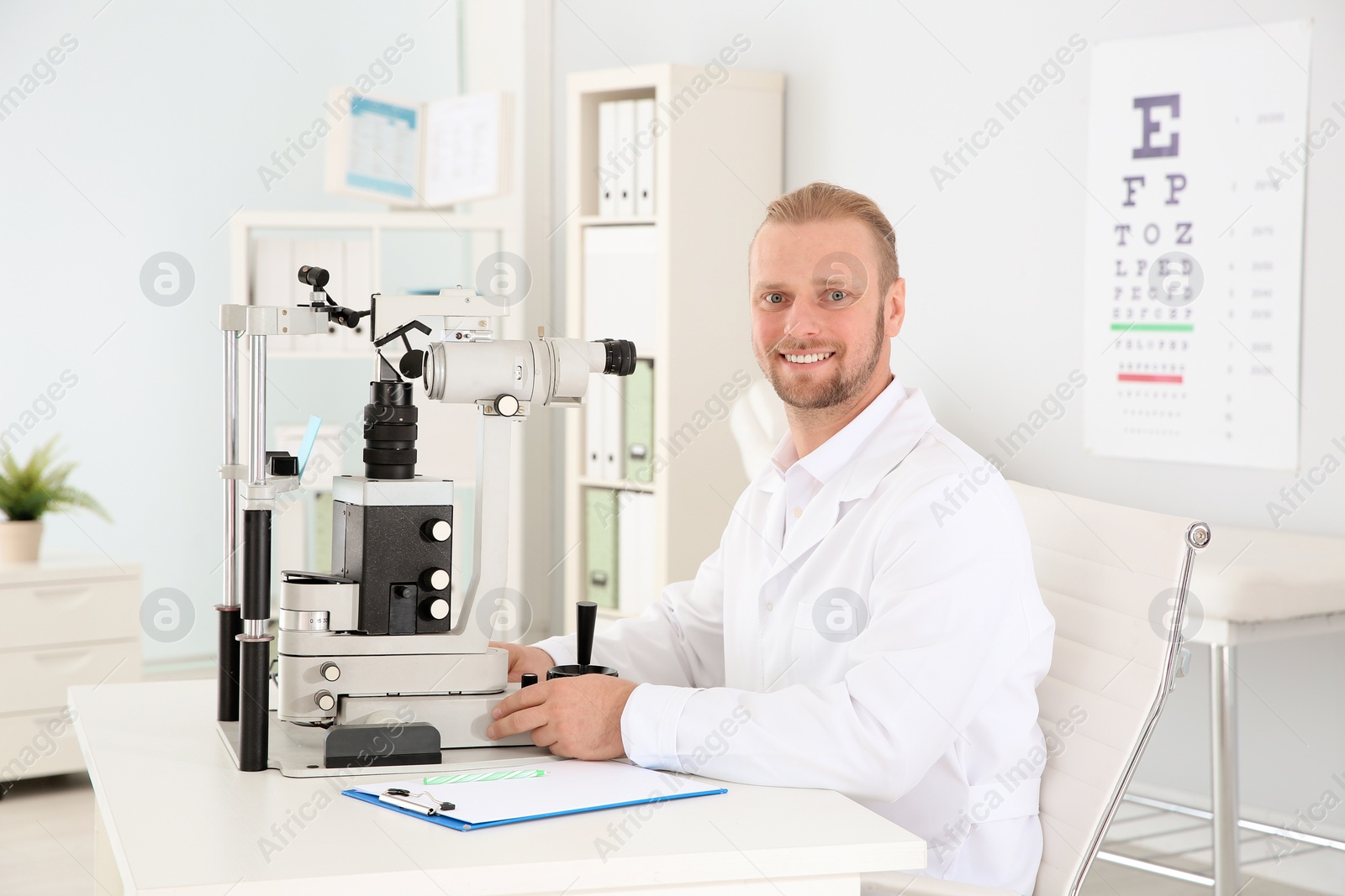 Photo of Male children's doctor with ophthalmic equipment in office