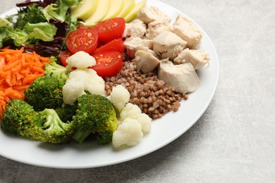 Photo of Balanced diet and healthy foods. Plate with different delicious products on grey table, closeup