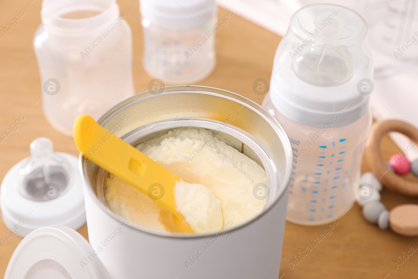 Photo of Can of powdered infant formula with scoop on table, closeup. Baby milk