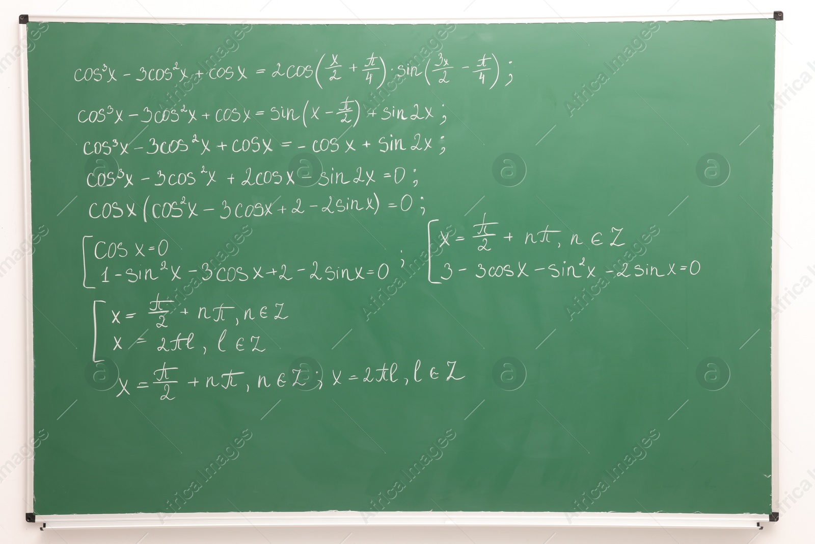 Photo of Many different math formulas written on green chalkboard