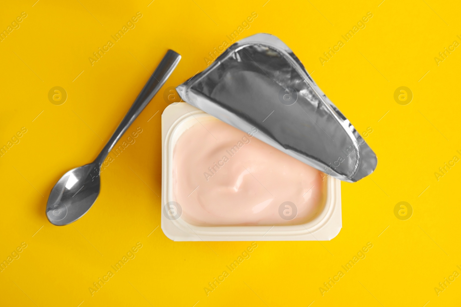 Photo of Tasty organic yogurt on yellow background, flat lay