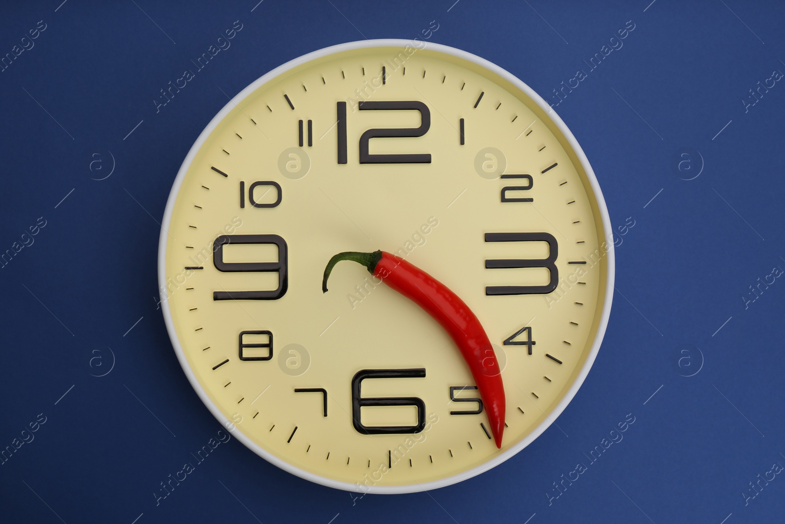 Photo of Clock with pepper on blue background, top view. Potency problem concept