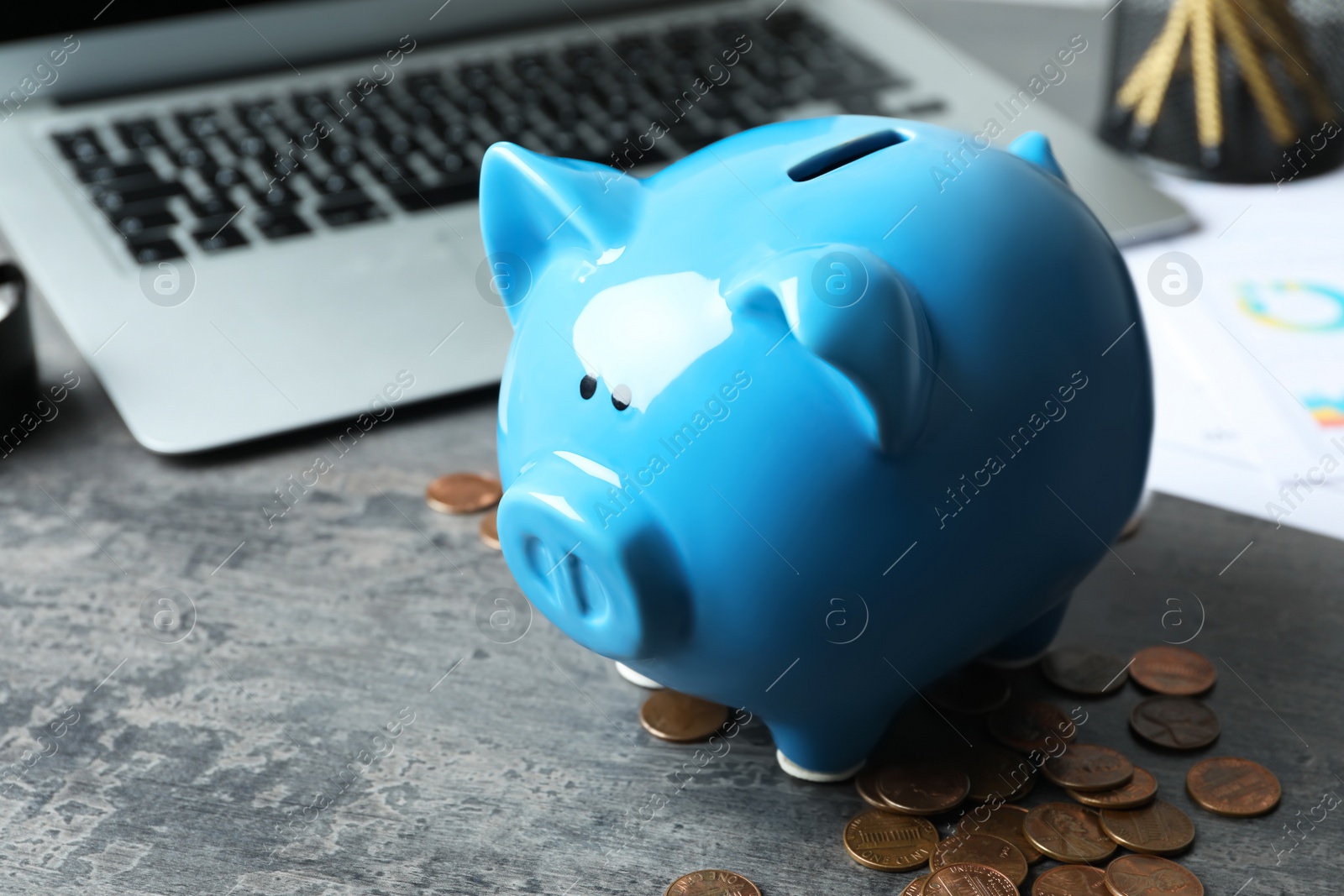 Photo of Blue piggy bank and money on grey table, closeup