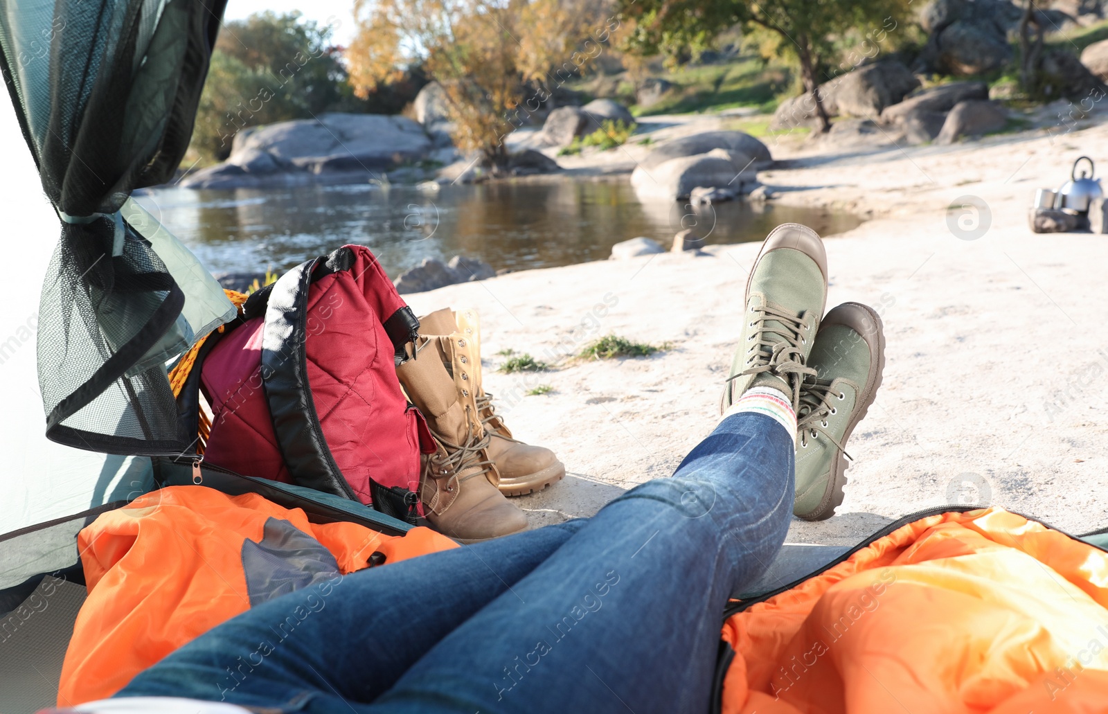 Photo of Woman lying on sleeping bag inside of camping tent, closeup