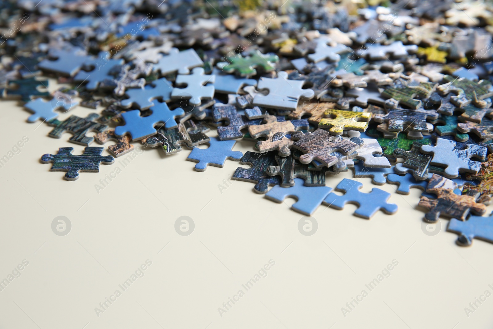 Photo of Puzzle pieces on white table, closeup view