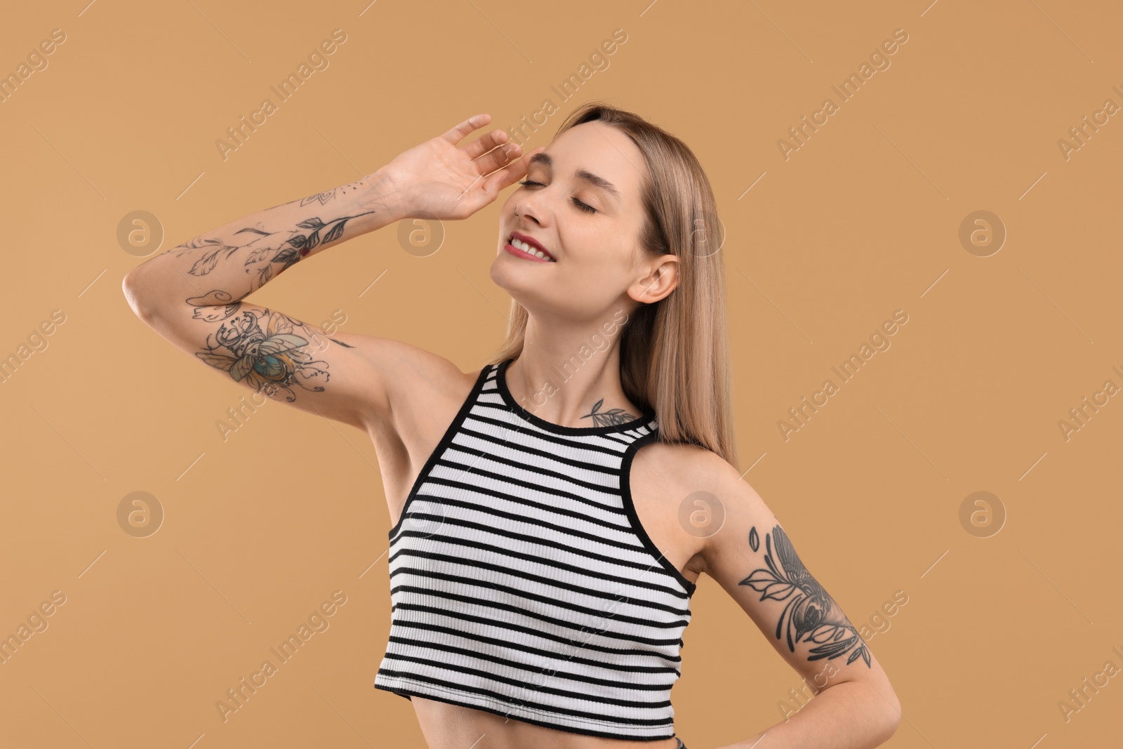 Photo of Portrait of beautiful tattooed woman on beige background