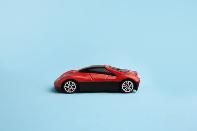 One red car on light blue background. Children`s toy