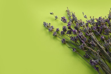 Photo of Beautiful lavender flowers on light green background, closeup. Space for text