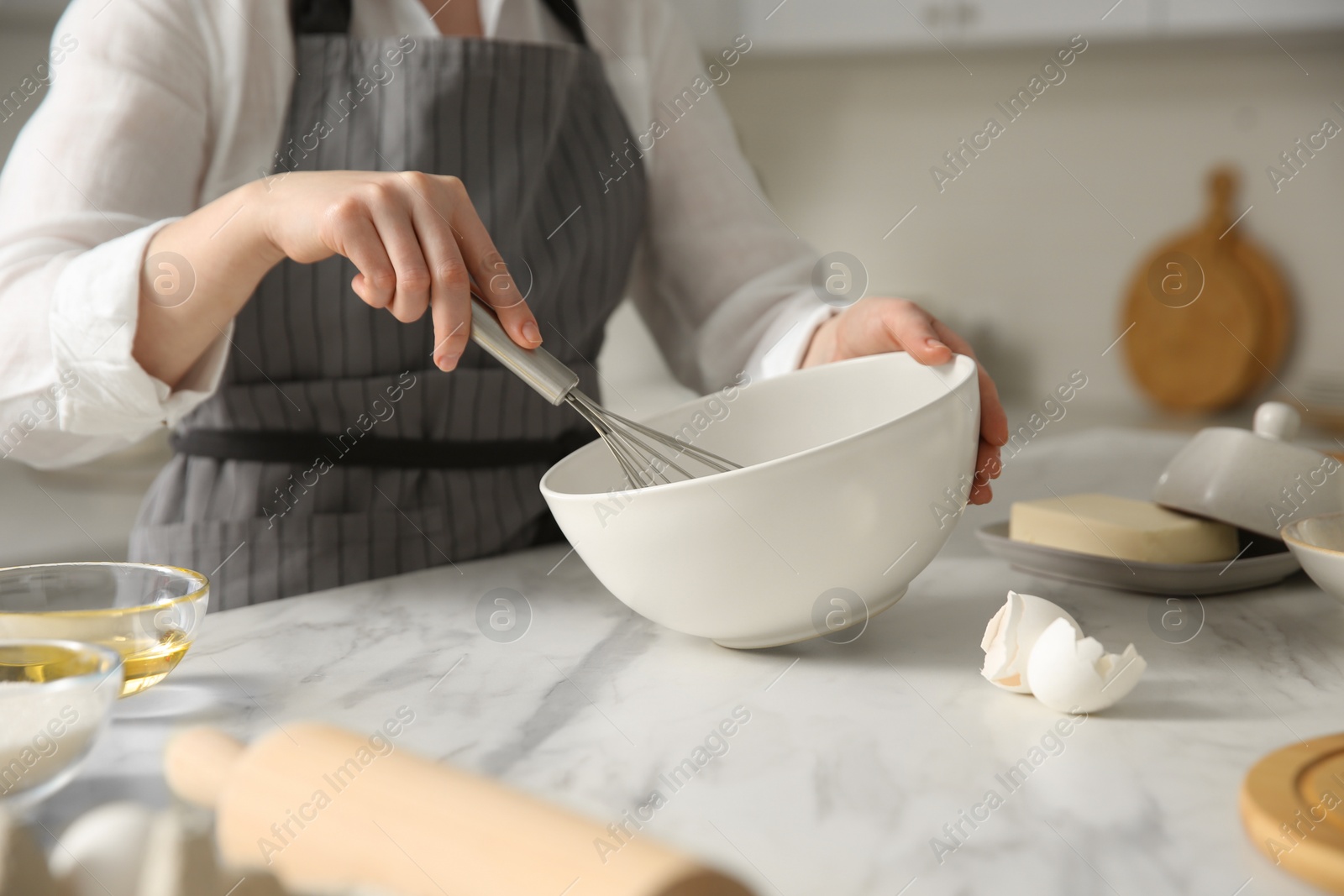 Photo of Woman making dough at table in kitchen, closeup