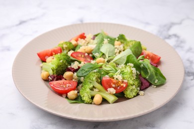 Photo of Healthy meal. Tasty salad with quinoa, chickpeas and vegetables on white marble table, closeup