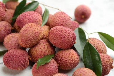 Photo of Fresh ripe lychee fruits on white table, closeup