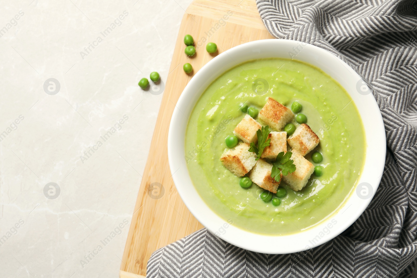 Photo of Flat lay composition with fresh vegetable detox soup made of green peas in dish and space for text on table