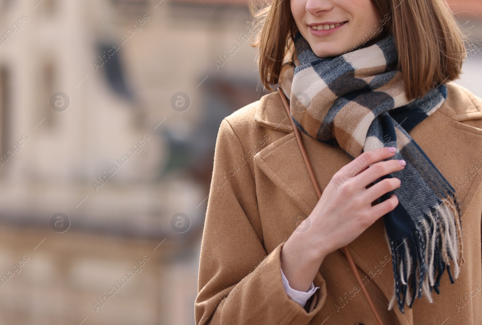 Photo of Beautiful woman in warm scarf outdoors, closeup. Space for text