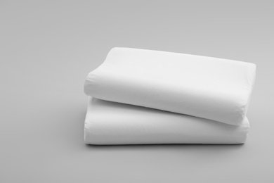 Photo of Clean soft orthopedic pillows on grey background