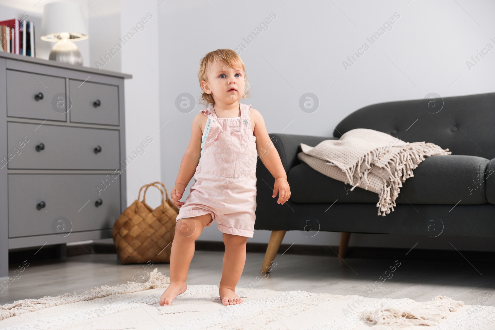 Photo of Cute baby learning to walk in living room