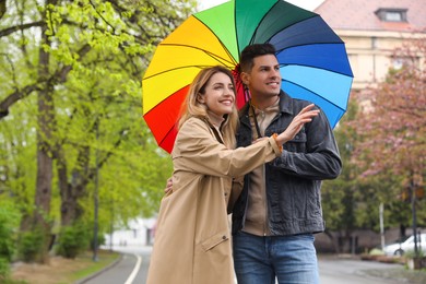 Lovely couple with umbrella walking on spring day