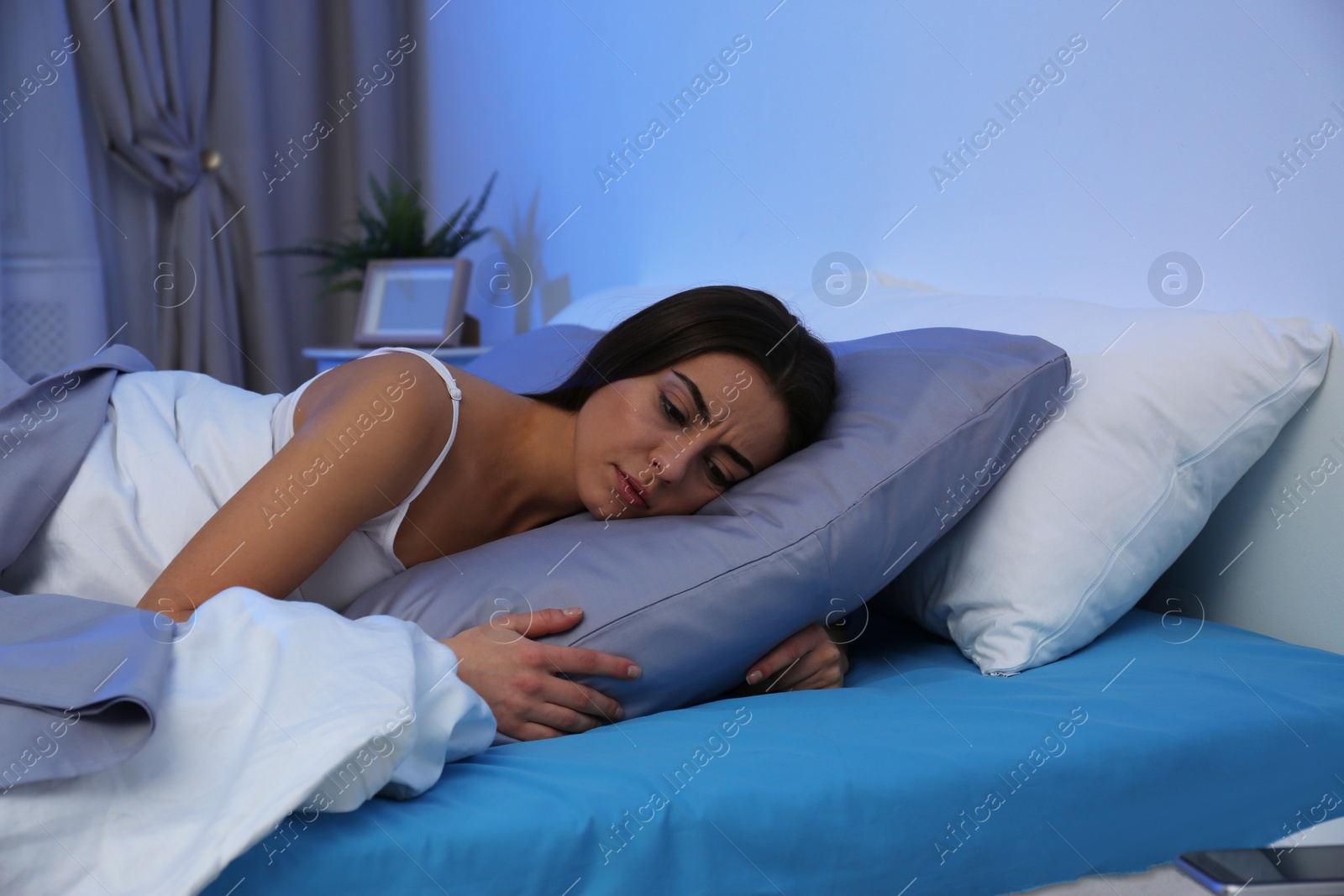 Photo of Young woman suffering from insomnia at home. Bedtime