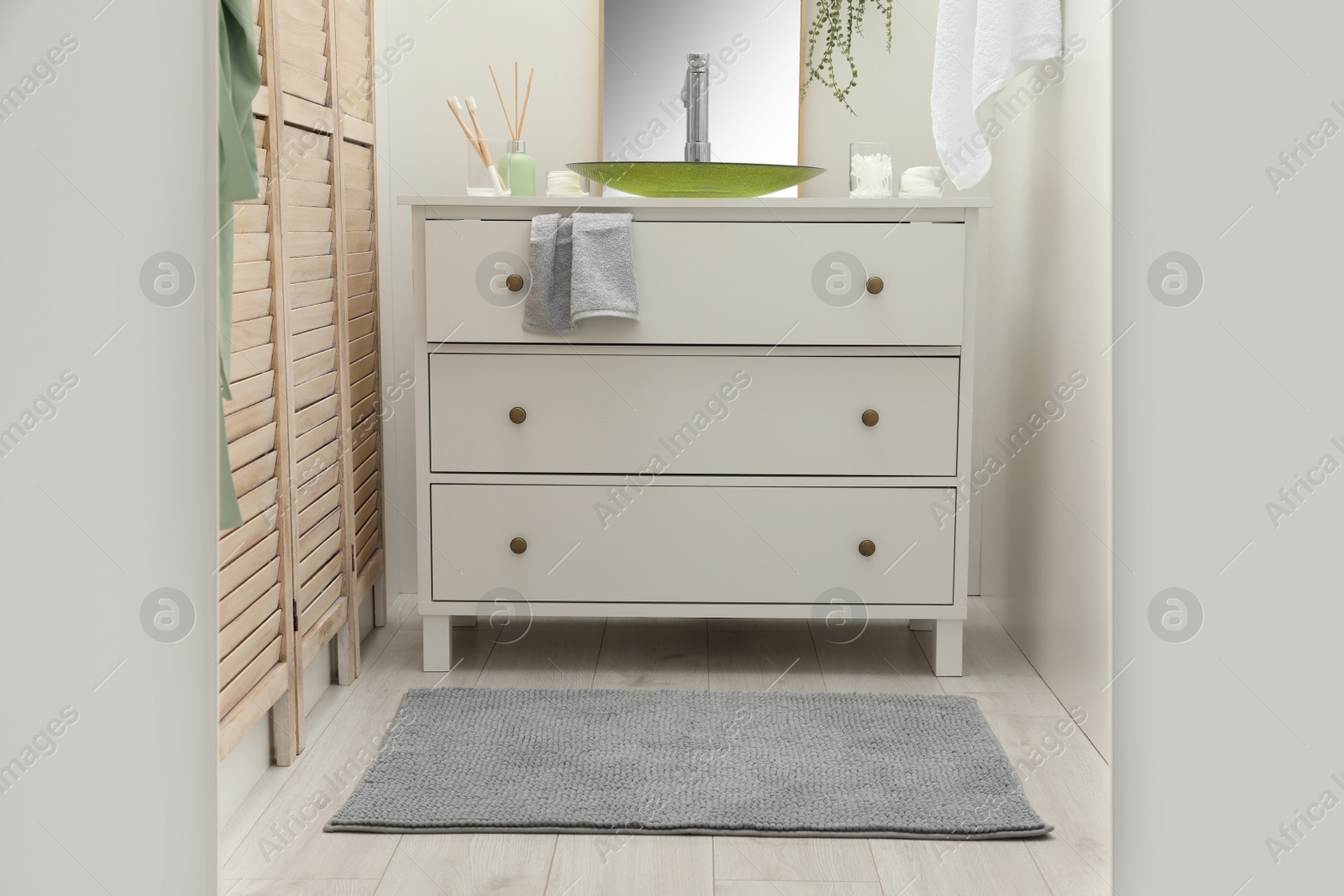 Photo of Mat near base cabinet with sink in bathroom