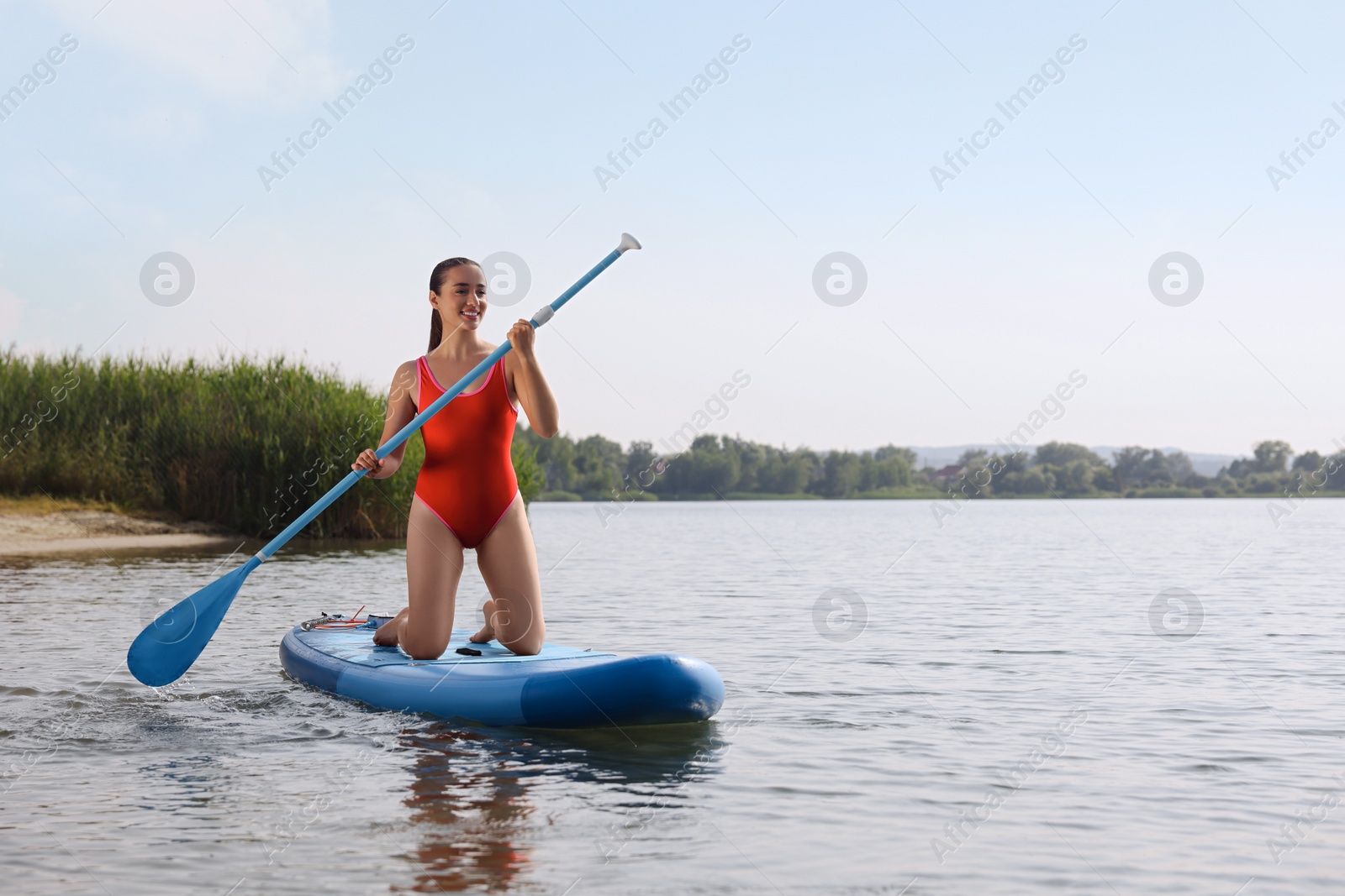 Photo of Woman paddle boarding on SUP board in sea, space for text