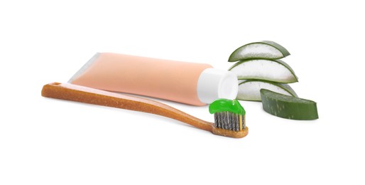 Tube of toothpaste, brush and cut aloe vera on white background