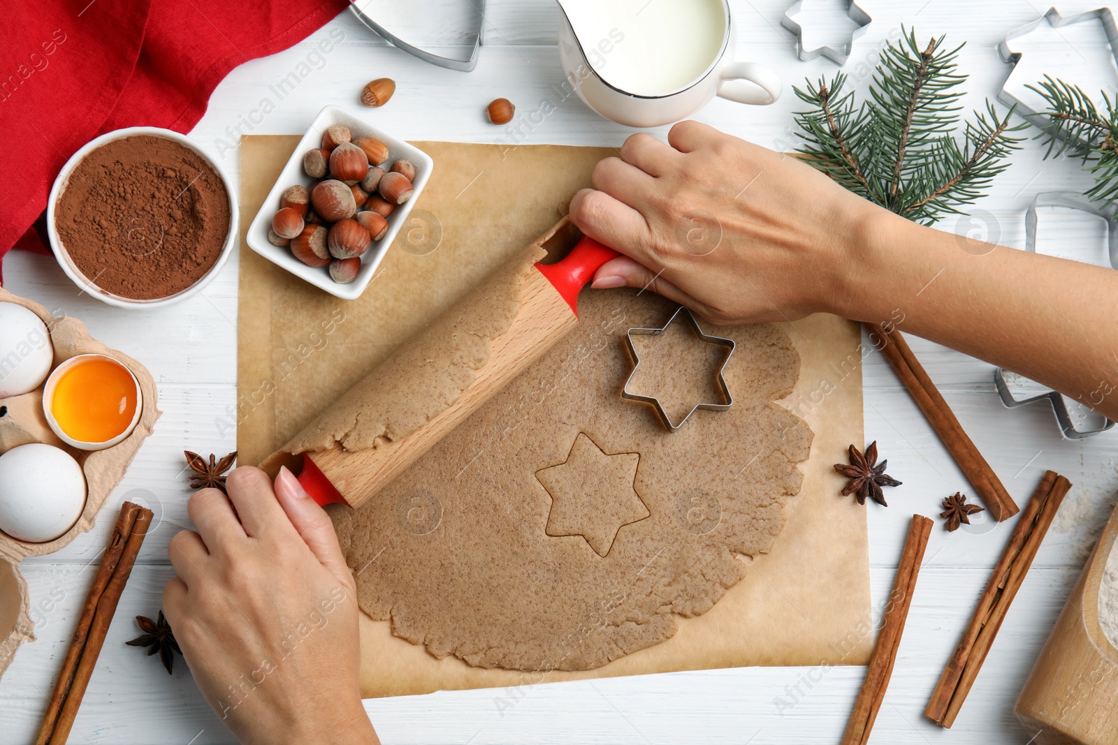 Photo of Woman rolling dough on white wooden table, top view. Homemade Christmas cookies