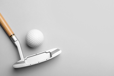 Golf ball and club on grey background, flat lay. Space for text