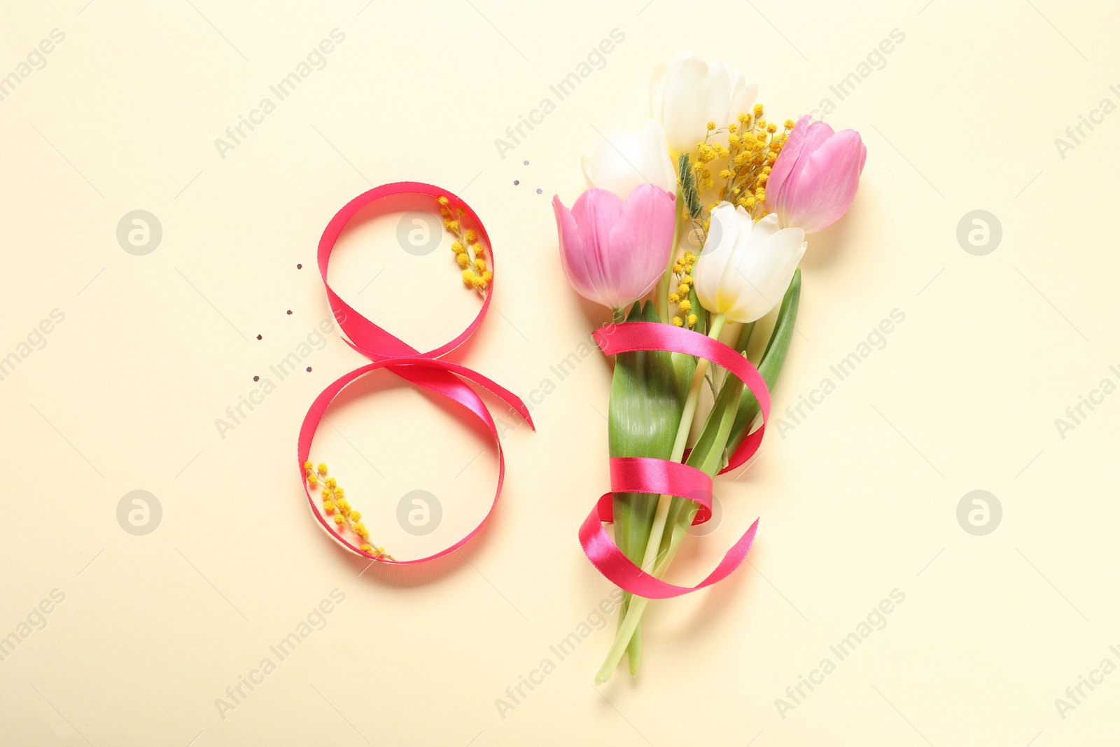 Photo of 8th of March greeting card design with red ribbon and beautiful flowers on beige background, flat lay. International Women's day