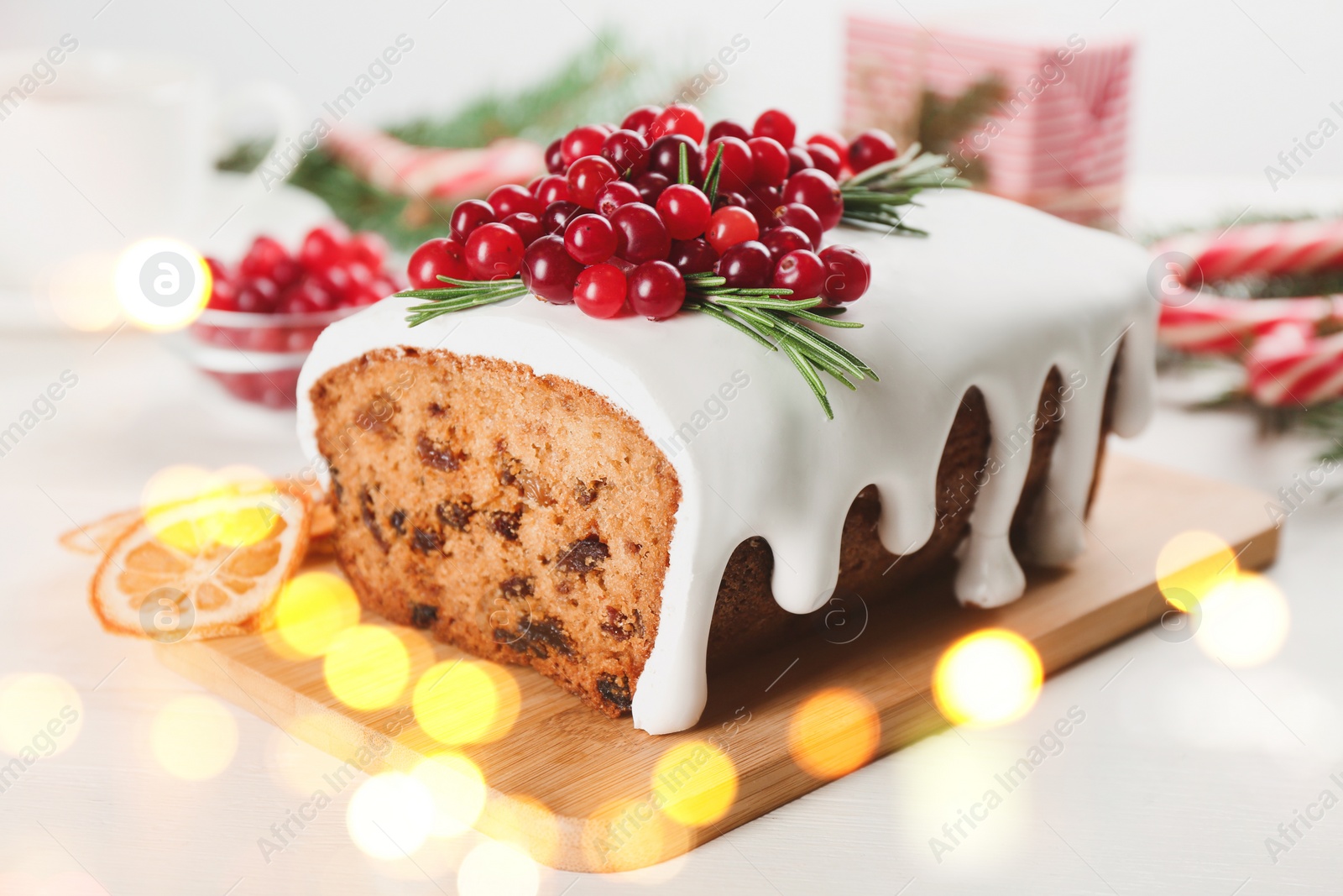 Image of Traditional classic Christmas cake decorated with cranberries on wooden board. Bokeh effect