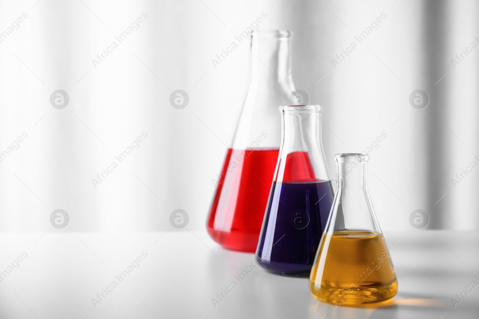 Photo of Different glassware with samples on table in chemistry laboratory. Space for text